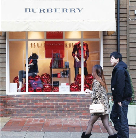 Two Chinese shoppers walking in front of a Burberry Store at Bicester Village. (Photo/China Daily)