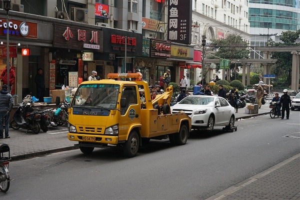 A car illegally parking on Hankou Road is being towed away today. Illegal parking on narrow streets around the Peoples Square and the Bund has been a nuisance to traffic in these areas for years and traffic police said they would spend the following months reinforcing crackdown in the area. Illegal parkers will be fined 200 yuan ($30)l, according to traffic law.(Photo/Shanghai Daily)