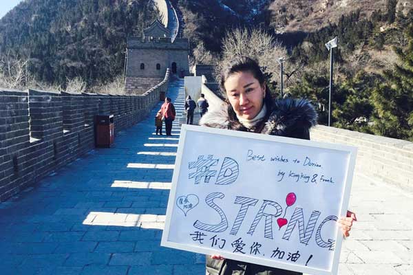 Xu Jin holds a sign with the words #D-Strong and We love you, come on at the Juyongguan section of the Great Wall in Beijing, Jan 12, 2016. (Photo/Asianewsphoto.com)