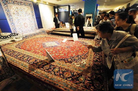 Tourists look at Persian carpets at the Iran Pavilion of the 2010 World Expo in Shanghai. (Photo: Xinhua/Wang Jianwei)