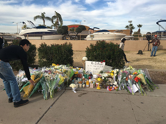 Mourners place flowers at the site where Chinese student Jiang Yue was shot and killed in an apparent road rage incident on Jan 16 in Temple, Arizona. A memorial was held Monday afternoon at the location where more than 200 people, including the victim's fellow students, members of the Chinese community and local residents, gathered to mourn her death.(Photo courtesy of Kristine Liu /chinadaily.com.cn)