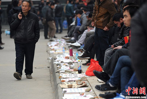 Undated photo shows dozens of migrant workers wait in cold weather to look for jobs in Chengdu. (Photo/Chinanews.com)