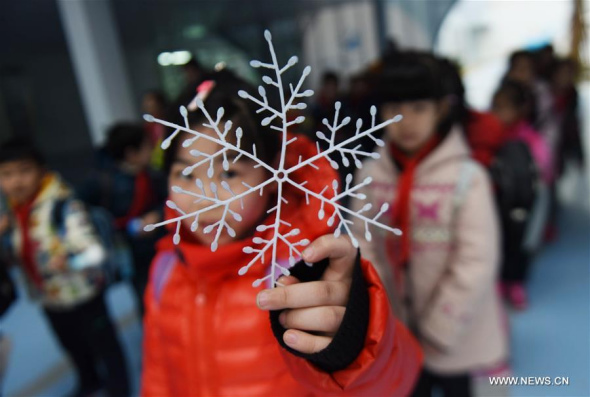 A student holds a plastic snowflake at Tianchang Primary School in Hangzhou, capital of east China's Zhejiang Province, on Jan. 20, 2016. The local education department decided to suspend classes within primary and secondary schools because of the strong cold front. (Photo: Xinhua/Long Wei)