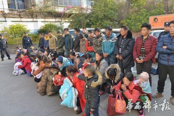Police escort suspects in a human trafficking ring through a railway station in Liangshan Yi Autonomous Prefecture, Southwest China's Sichuan Province, Jan. 18, 2016. (Photo/West China City News)