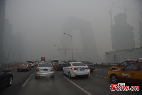 Vehicles run amid heavy smog and thick fog in Beijing, Dec. 25, 2015. (Photo: China News Service/Jin Shuo)