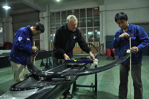 Klaus Filter instructs Chinese workers at Sino Eagle Group, a leading manufacturer of rowing shells in Fuyang, Zhejiang province. The German designer is a witnessand a major contributorto the company's growth over the past two decades.(Photo: China Daily/Liu Xiangrui)