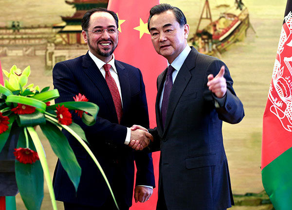 Foreign Minister Wang Yi and his Afghan counterpart Salahuddin Rabbani meet reporters after a news conference in Beijing on Tuesday. FENG YONGBIN/CHINA DAILY