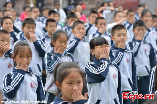 One thousand students practice anti-smoking hand gestures at a school in Beijing, May 11, 2015. (Photo/IC)