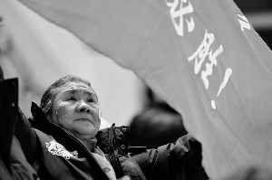 Li holds a banner at the stadium, with two Chinese national flags painted on her cheeks. (Photo/www.tlnews.cn)