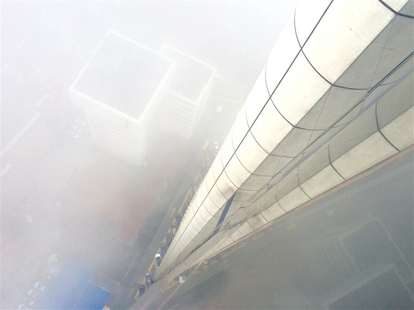 A bird's eye view of the city from 38th floor. Heavy fog engulfed the city this morning due to the high humidity and weak winds, which lowers the visibility in most areas to less than 500 meters, forecasters said.(Photo/Shanghai Daily)