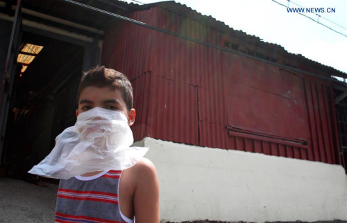 A boy covers his face as an employee of the Health Ministry fumigates his house against the Aedes aegypti mosquito that can spread Zika virus at La Carpio neighborhood in San Jose, capital of Costa Rica, on Jan. 28, 2016. (Photo: Xinhua/Kent Gilbert) 