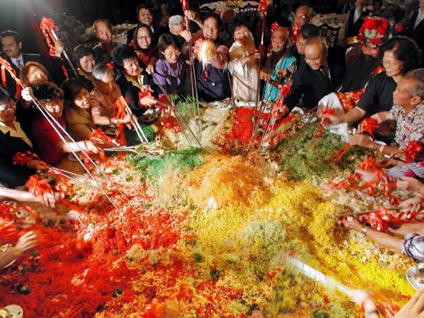 Yu Sheng, or Yee Sang, is a traditional food ritual during the Lunar New Year. Diners toss ingredients high in the air to wish for luck and happiness. (Photo/Xinhua) 