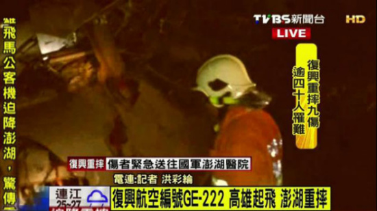 A still image taken from TVBS footage shows a rescue worker at the crash site after TransAsia Airways flight GE222 crash landed in Penghu county, Taiwan, July 23, 2014.(Photo/tvbs.com.tw)