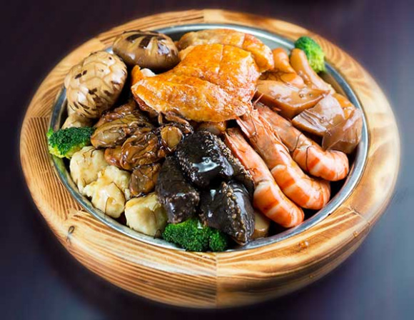 Poon Choi. HK O'Man restaurant's signature dishes include the plain rice with lard, the mixed HK O'Man pig knuckle and poon choi, or basin cuisine, served in large wooden, porcelain or metal basins. (Photo provided to China Daily)