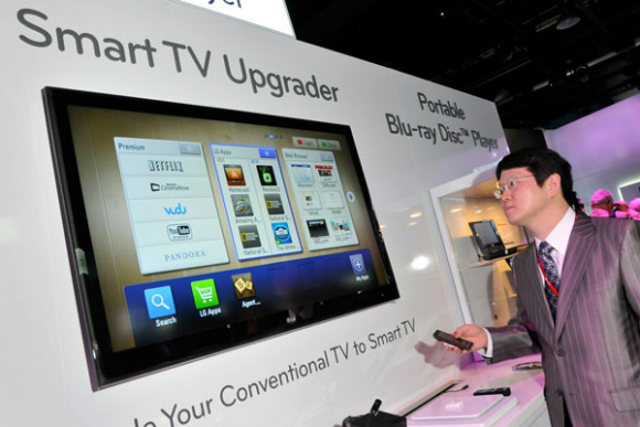 A man controls a smart TV upgrader set-top box with a smart phone at the Consumer Electronics Show in Las Vegas. (Photo/China Daily)