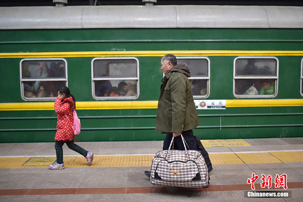 Passengers walk to board an extra train bound to Anqing city, East China's Anhui province, at Beijing West Railway Station on Jan 24, 2016. The train marks the start of travel rush of the 40-day Spring Festival travel. (Photo/Chinanews.com)