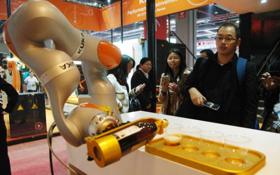 Kuka robot pours wine at a fair in Shanghai in November 2015. (Photo/China Daily)