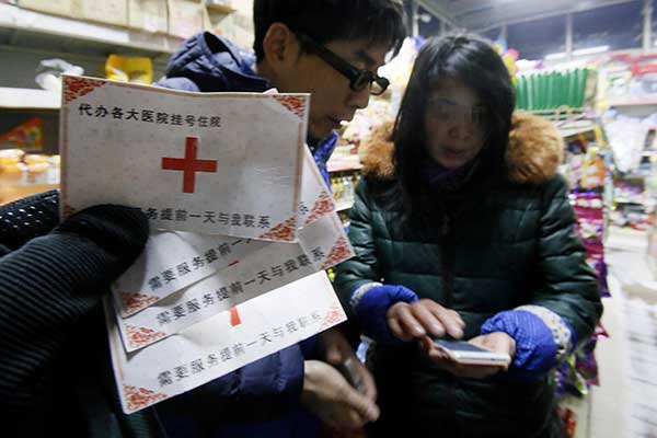 Contact cards promising to schedule a doctor's appointment for patients are seized by police from a woman near Beijing Children's Hospital in January. Cao Boyuan / For China Daily