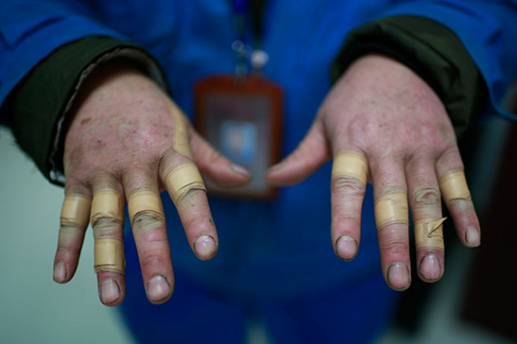 Plumber Qiu Tianpei prepares new water meters at the maintenance station where he works in Jing'an district. His fingers are bandaged because of heavy work in difficult conditions. (XIAO JUNWEI/CHINA DAILY)