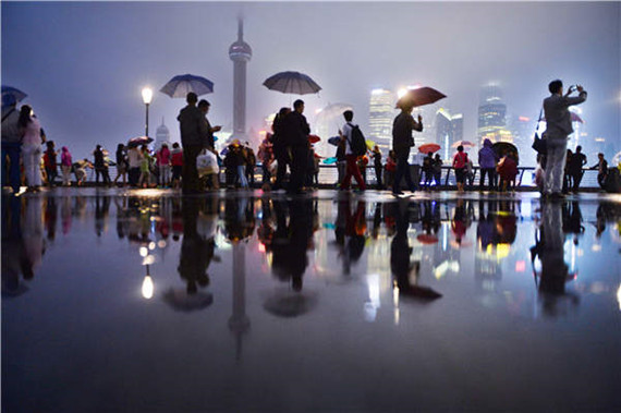 Visitors at Shanghai's Bund on a rainy night. Photos provided to China Daily