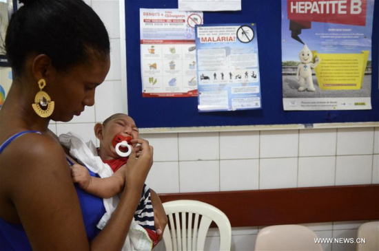 Gabrielly Santana da Paz holds her child who suffered microcephaly while waiting for examination at the Oswaldo Cruz Hospital, in Cabo de Santo Agostinho, 35 km from Recife, capital of Pernambuco in northeastern Brazil, on Feb. 1, 2016. (Photo/Xinhua)