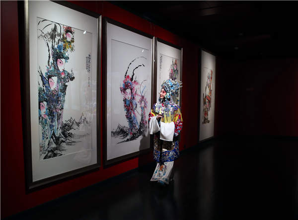 A Peking Opera performer visits the ongoing exhibition, Rhythm of Brush and Ink, Exhibition of Chinese Theatric Figure Paintings, at the National Center for the Performing Arts. Jiang Dong / China Daily