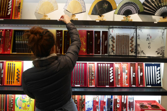 A salesperson at the Yunhong Chopsticks store in Manhattan's Chinatown. The shop's most popular chopsticks with tourists are those that feature zodiac signs. AMY HE / CHINA DAILY
