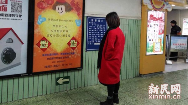 A passenger looks at the anti-forced marriage advertisement at Dongzhimen subway station in Beijing on Thursday, Feb. 4, 2016. (Photo/xinmin.cn)