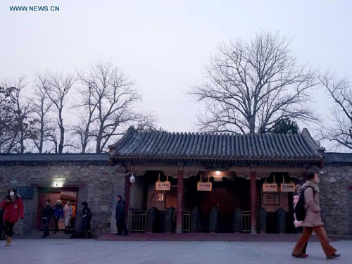 Tourists walk out of the Summer Palace in Beijing, capital of China, Dec. 19, 2015. Beijing issued its second red alert for air pollution on Friday. The red alert, the most serious level, will last from 7 a.m. Saturday to 12 p.m. Tuesday. (Photo: Xinhua/Chen Jianli)