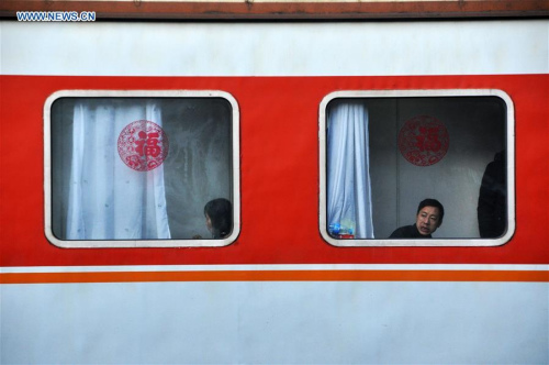 Passengers take a train to return home for family reunion at Caohai Railway Station in Guizhou, capital of southwest China's Guizhou Province, Jan. 28, 2016. (Photo: Xinhua/Yang Wenbin)