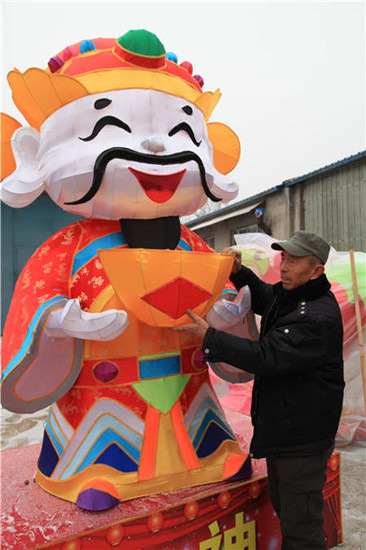 Guo Erniu with the lantern of the God of Fortune, a major product of his company this year, at his studio in Taiyuan, Shanxi province. Photos by Sun Ruisheng / China Daily