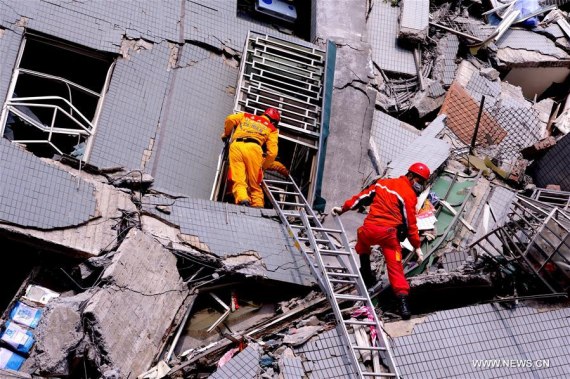 Rescuers try to look for victims at the site where a building collapsed during an earthquake in Tainan City, southeast China's Taiwan, Feb. 6, 2016. (Photo: Xinhua/Zhang Guojun)