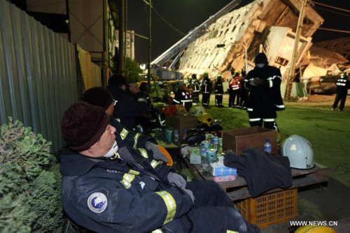 Rescuers take turns to have a break near a collapsed building in Tainan City, southeast China's Taiwan, on Feb. 7, 2016. (Photo/Xinhua)