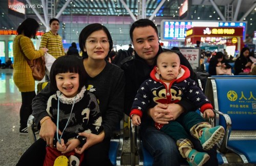 Mr. Zhao, a migrant worker from east China's Shandong Province, waits for train with his wife, 4-year-old daughter and 16-month-old son at Shenzhen Railway Station in Shenzhen, south China's Guangdong Province, Feb. 5, 2016. Lots of migrant workers come back home for family union with their children during the Spring Festival. (Xinhua/Mao Siqian)