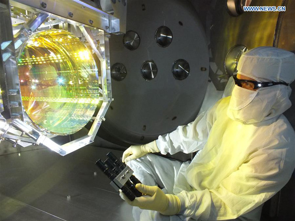 File photo shows a technician inspects one of LIGO's core optics (mirrors) by illuminating its surface with light at a glancing angles, prior to sealing up the chamber and pumping the vacuum system down. U.S. scientists said Thursday they have detected the existence of gravitational waves, which were predicted by Albert Einstein's theory of general relativity 100 years ago. (Xinhua/Matt Heintze/Caltech/MIT/LIGO Lab)