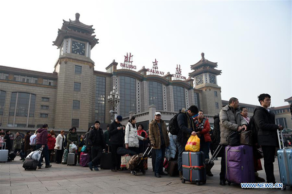 Passengers leave Beijing Railway Station in downtown Beijing, capital of China, Feb. 12, 2016. Railway stations around the nation witnessed surging passenger flows on Friday as the Spring Festival came to the end and people started to return to school and work. (Xinhua/Ju Huanzong)