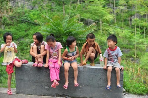 Qin Xiaohui (R) plays with the other children in his village on July 5, 2012. Qin Xiaohui, then 6, lives in Banlie Village of Bansheng Township in Dahua Yao Autonomous County, South China's Guangxi Zhuang Autonomous Region. (Photo/Xinhua)