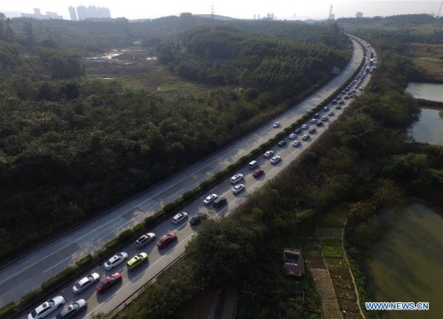 An aerial photo taken on Feb. 12, 2016 shows vehicles moving slowly on an expressway near Nanning, south China's Guangxi Zhuang Autonomous Region. Highways and railroads across China have seen increasing passenger flow while millions of Chinese return to work as the week-long Spring Festival holiday comes to an end. (Xinhua/Huang Xiaobang)