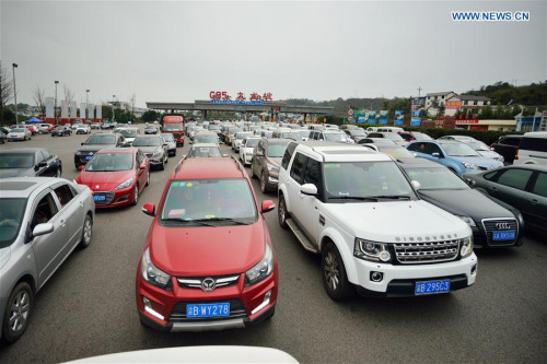 Vehicles queue to pass the Jiulongpo Toll Station on the Chongqing-Kunming Highway in Chongqing, southwest China, Feb. 13, 2016. (Photo: Xinhua/Chen Xingyu) 