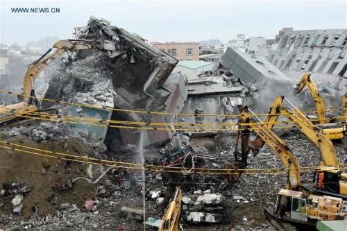 Heavy machines work at the rescue site of the Wei Guan building toppled by a strong quake in Tainan, southeast China's Taiwan, Feb. 10, 2016. (Photo: Xinhua/Zhang Guojun)