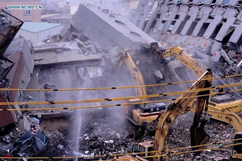 Heavy machines work at the rescue site of the Wei Guan building toppled by a strong quake in Tainan, southeast China's Taiwan, Feb. 10, 2016. (Photo: Xinhua/Zhang Guojun)