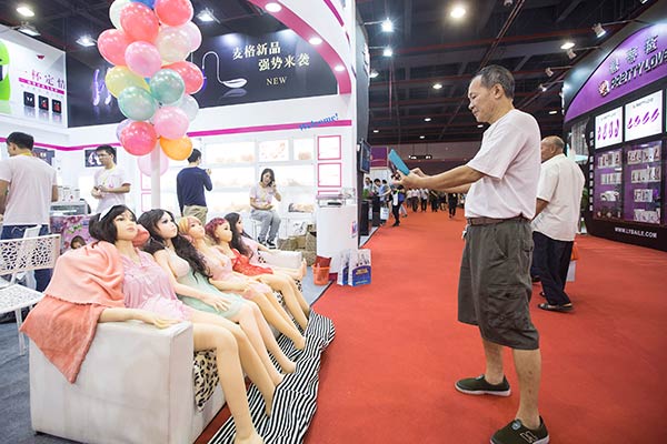 A visitor takes photos using his smartphone at a sex culture fair in Guangzhou, Guangdong province, in November, 2015. (Photo: China Daily/Lin Hongxian)