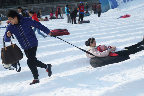 Visitors play in the snow at Taoranting Park in Beijing during the Spring Festival holiday last week.(Photo by Tian Baoxi/China Daily)