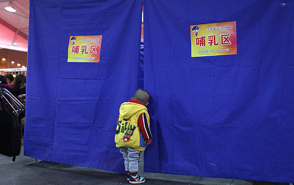 A three-year-old boy peers curiously inside a mother-and-baby room at Guangzhou Railway Station in February 2015. The temporary room was prepared for the annual Spring Festival holiday travel rush. Bai Shi / For China Daily