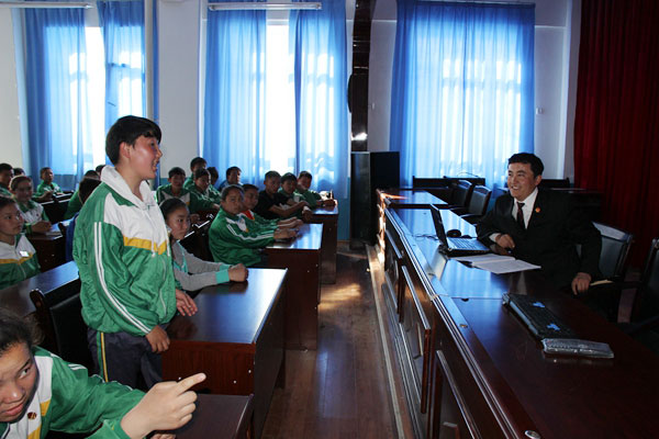 Students pay close attention to Mauken's words on a lecture at the Husbandry Boarding Primary and Middle School of Qiakuertu Town in May, 2015. (Photo provided to chinadaily.com.cn)