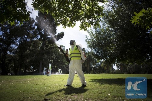 Argentina's Environment and Public Space Ministry fumigation brigade members spay insecticide in an area of Saavedra Park, in an effort to control the Aedes aegypti mosquito, in Buenos Aires, capital of Argentina, on Feb. 11, 2016. (Photo: Xinhua/Martin Zabala)