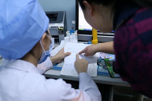 A doctor talks with a parent at the Capital Institute of Pediatrics in Beijing in January. (Photo: China Daily/Zhu Huiqing)