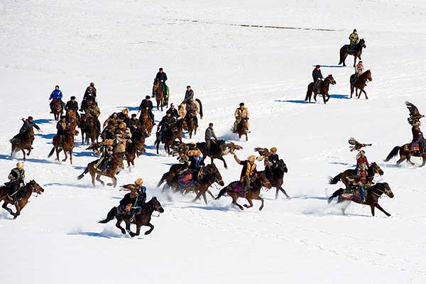 Local Kazak herdsmen participate in a traditional hunting competition for rabbits or foxes on horseback with eagles that they have trained for years, in Yining, Xinjiang Uygur autonomous region, on Thursday.(Photo: China Daily/Qin Jie)