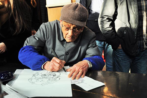 Guo Taiyun demonstrates his skills in making woodblock prints in a museum in Kaifeng, Henan province. (Photo by Liu Xiangrui/China Daily)