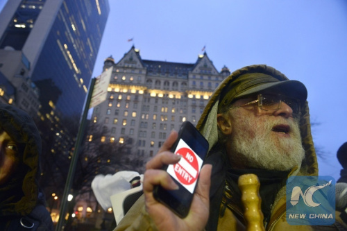 An iPhone user attends a rally at the Apple flagship store in Manhattan to support the company's refusal to help the FBI access the cell phone in New York, the United States, Feb. 23, 2016. Apple, a technology company in Silicon Valley, last Wednesday opposed a judge's order to help the Federal Bureau of Investigation (FBI) access the phone of a terrorist killer. (Photo: Xinhua/Wang Lei)